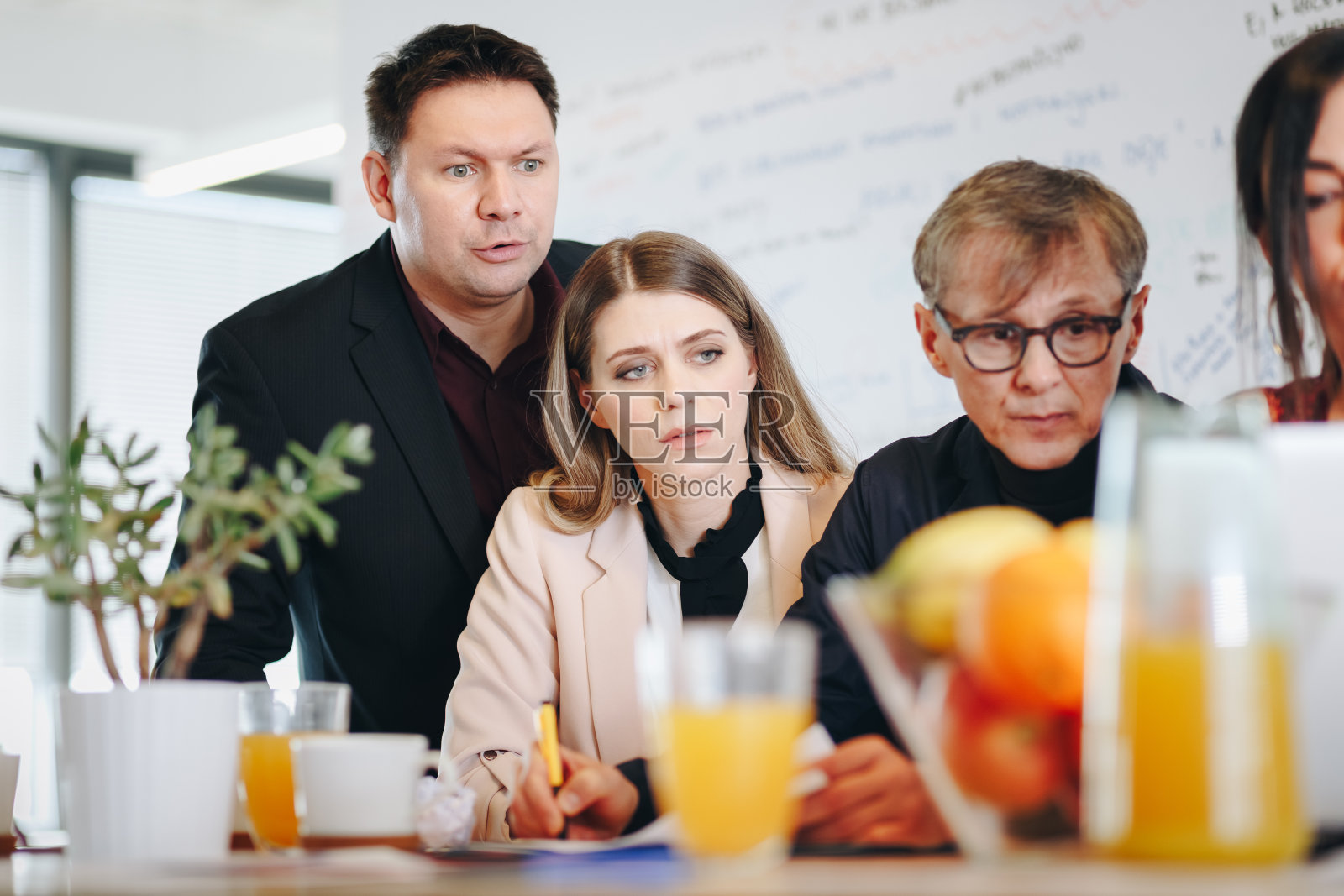 真实的同事使用笔记本电脑与他们的上级讨论项目的肖像。照片摄影图片