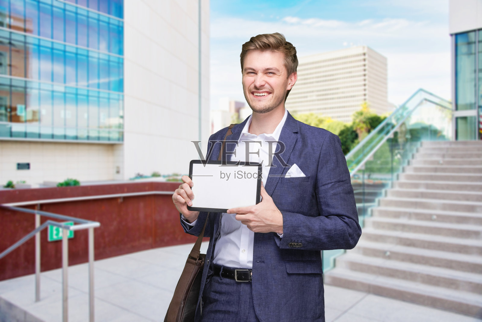 一人一男/一人/齐腰以上/正面观20-29岁成年帅哥棕色头发白人男性/年轻男性经理/商人/商人站着穿着商务装/肩包/邮差包/背包-包照片摄影图片