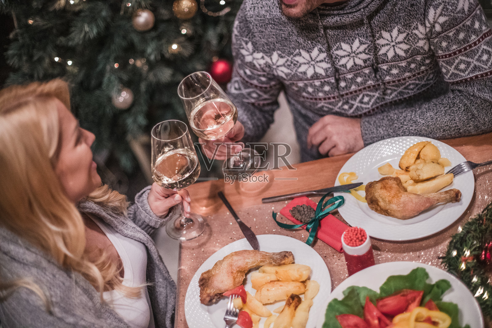 一对年轻英俊的夫妇在平安夜享用烛光晚餐。照片摄影图片