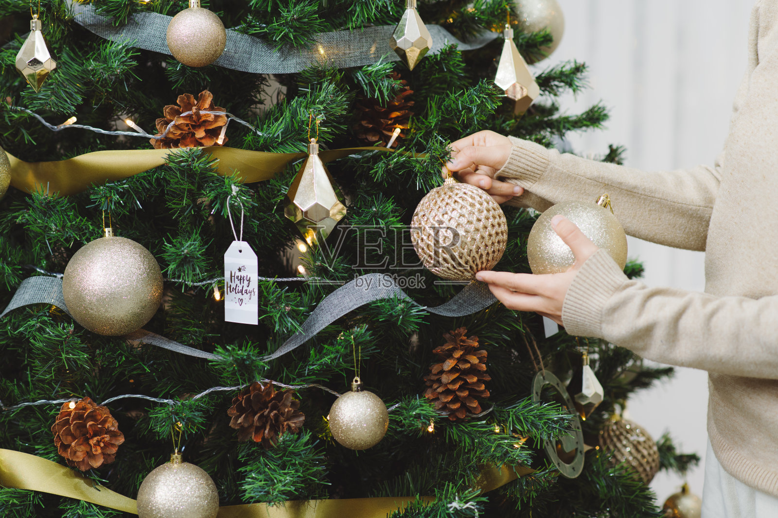 快乐年轻的亚洲妇女装饰圣诞树在家里照片摄影图片