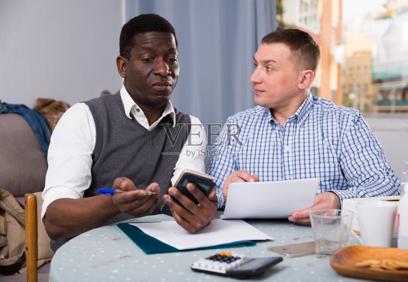 两个麻烦的朋友，家里有电话和文件照片摄影图片