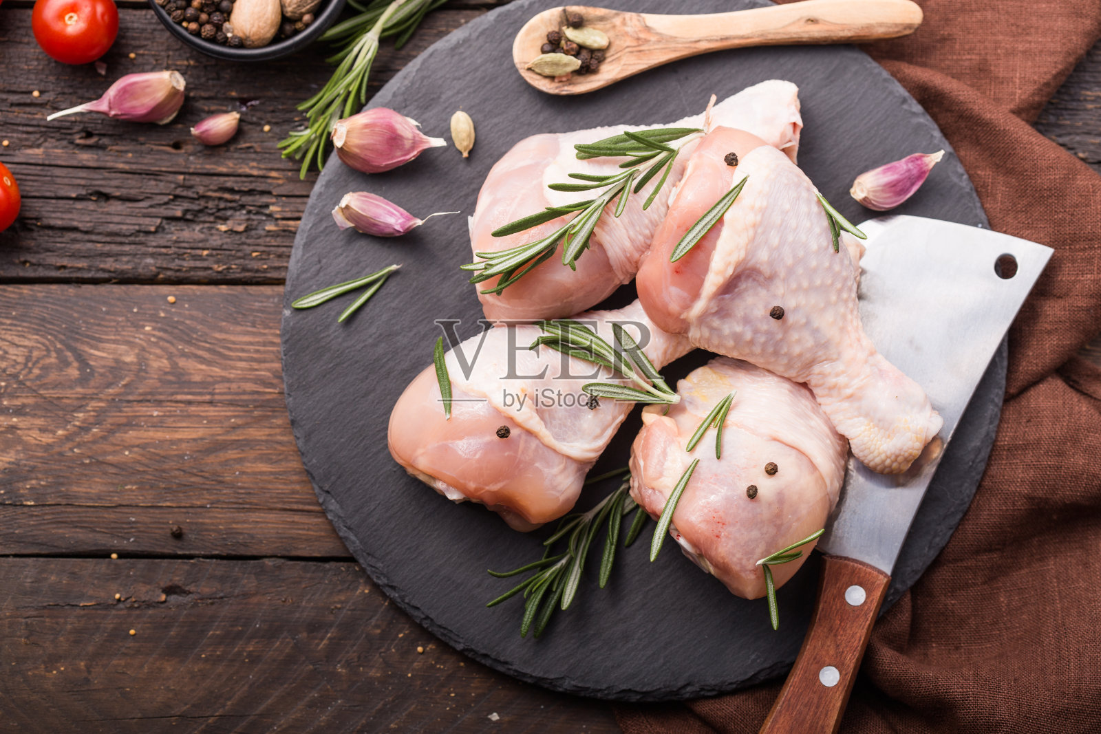 鸡肉。生的未煮过的鸡腿或鸡腿放在石板上，与烹饪材料一起俯视图照片摄影图片