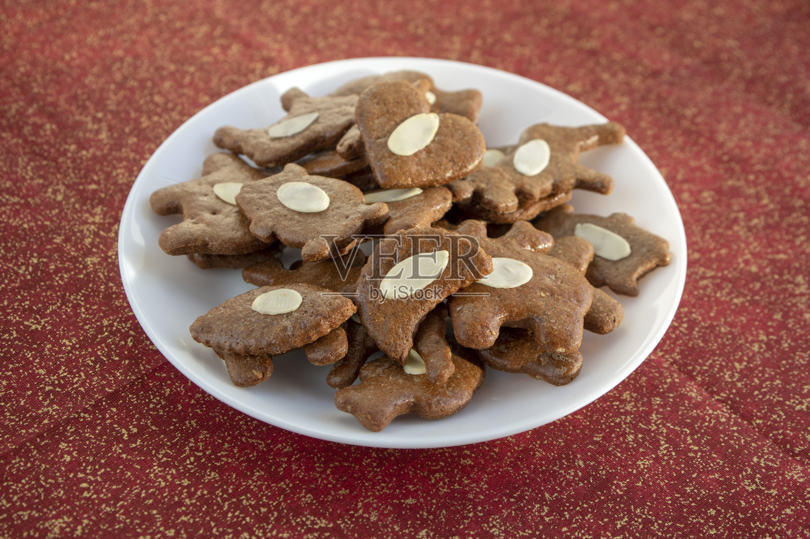 棕色的摩拉维亚黑色姜饼配杏仁片，白色盘子里放着圣诞饼干照片摄影图片