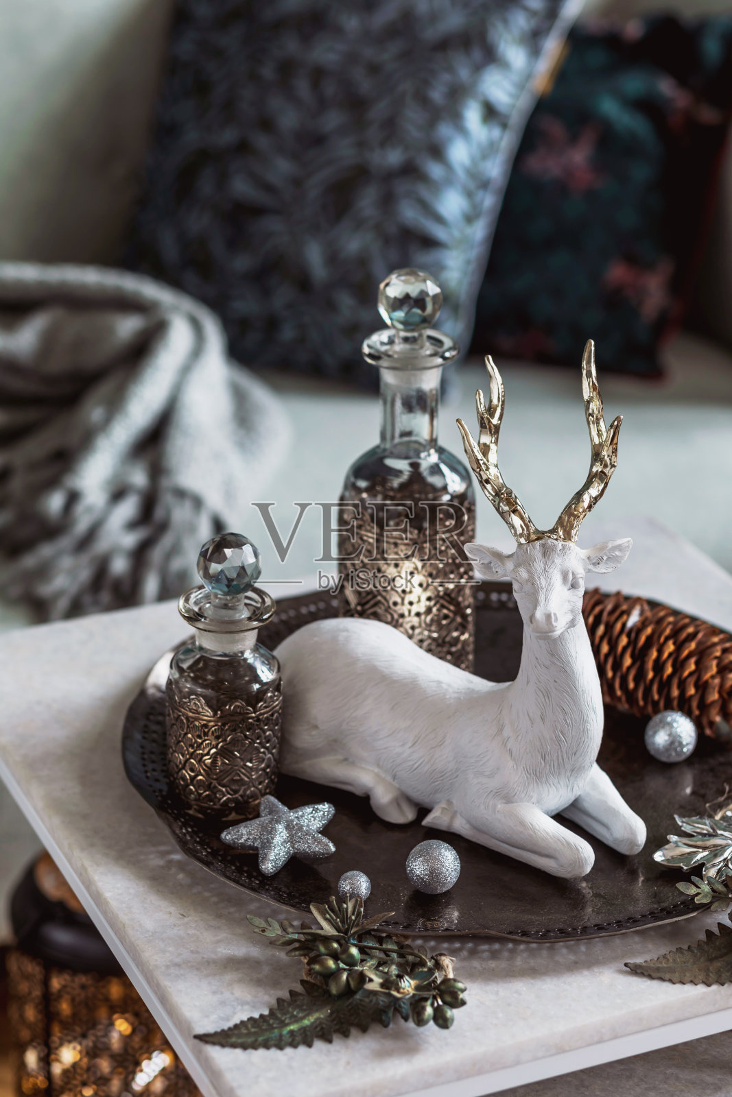 客厅大理石桌上的圣诞摆设，有漂亮的装饰品，圣诞树、鹿、蜡烛、星星、灯光和优雅的配饰，样机，圣诞快乐照片摄影图片