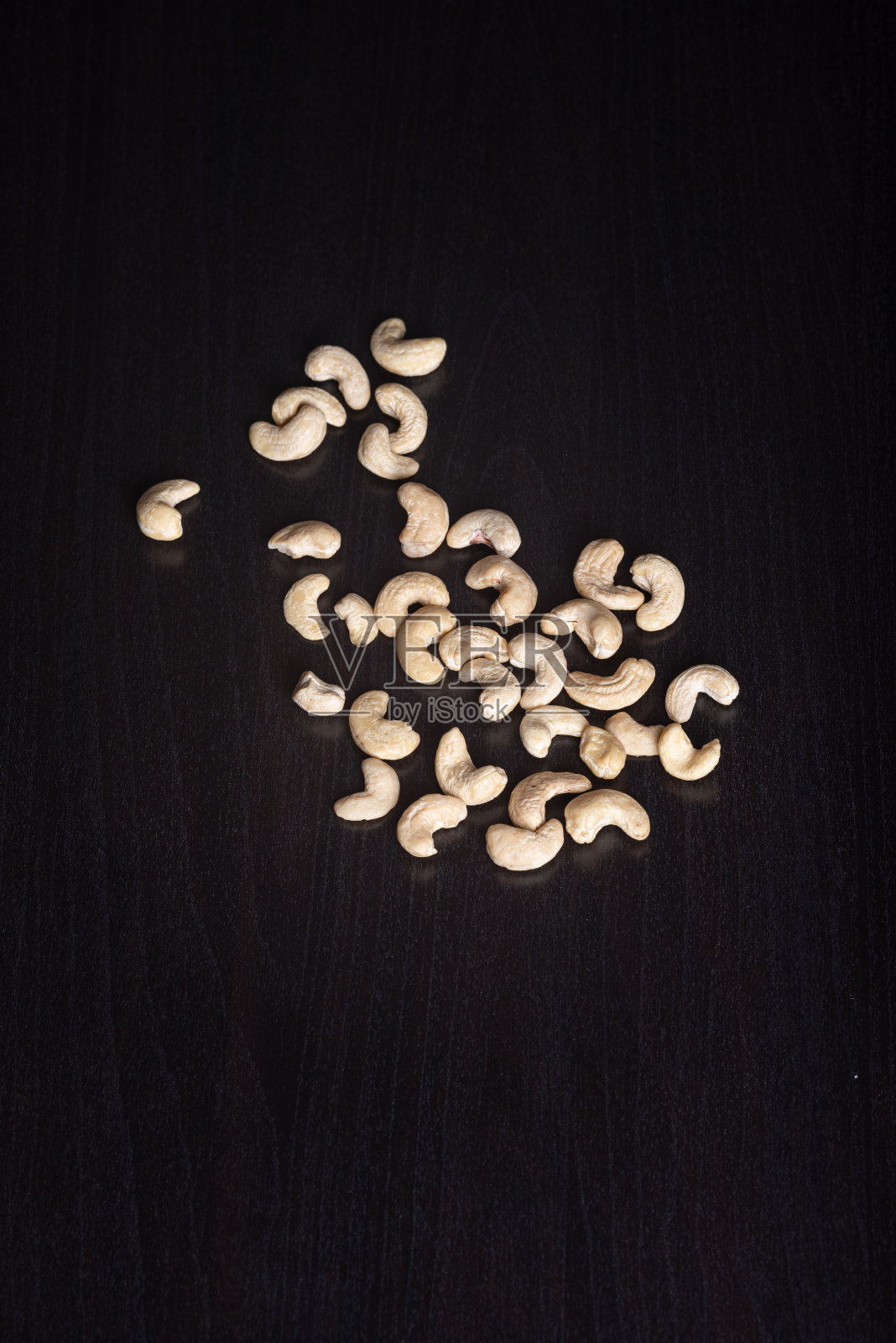 腰果放在黑木板上照片摄影图片