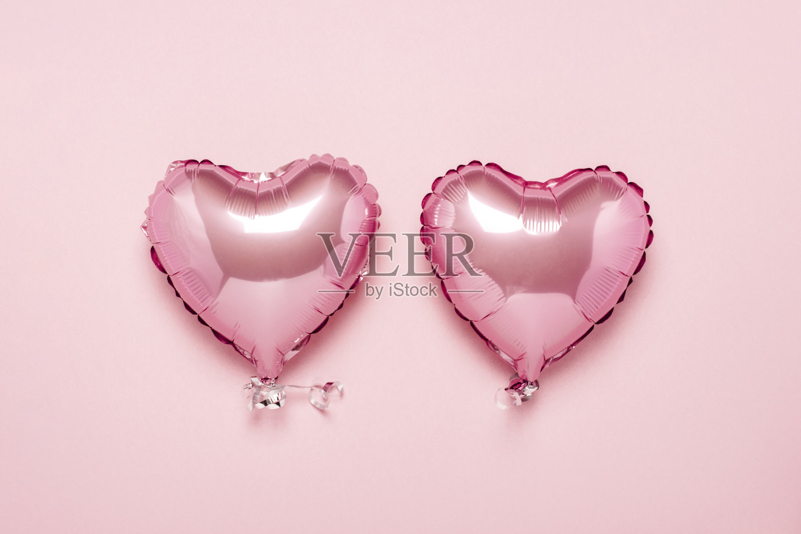 粉色背景上的两个粉色心形气球。概念情人节，婚礼装饰。箔球。平躺，俯视图照片摄影图片