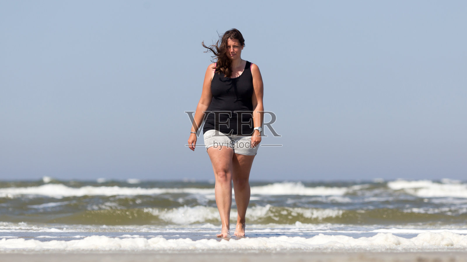 一个女人走在荷兰小岛的海滩上照片摄影图片