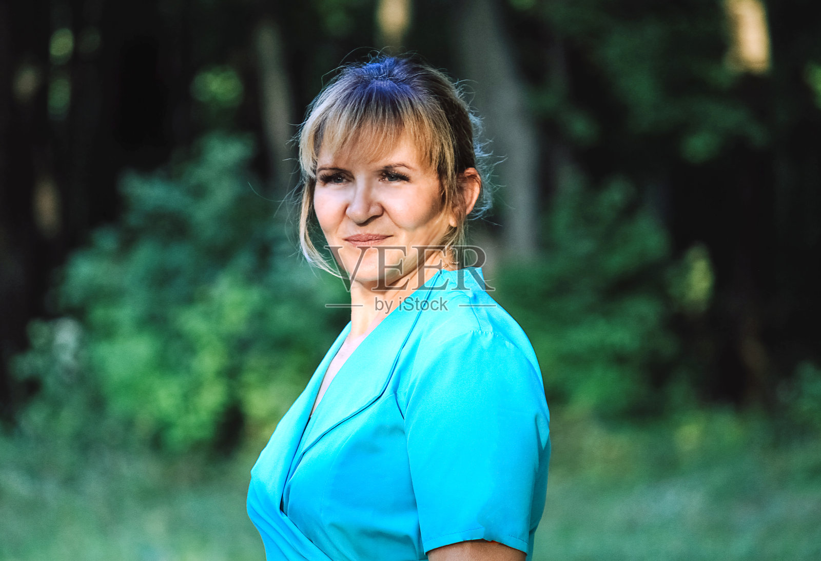 阳光下一个穿着蓝色裙子的年轻女子的肖像照片摄影图片