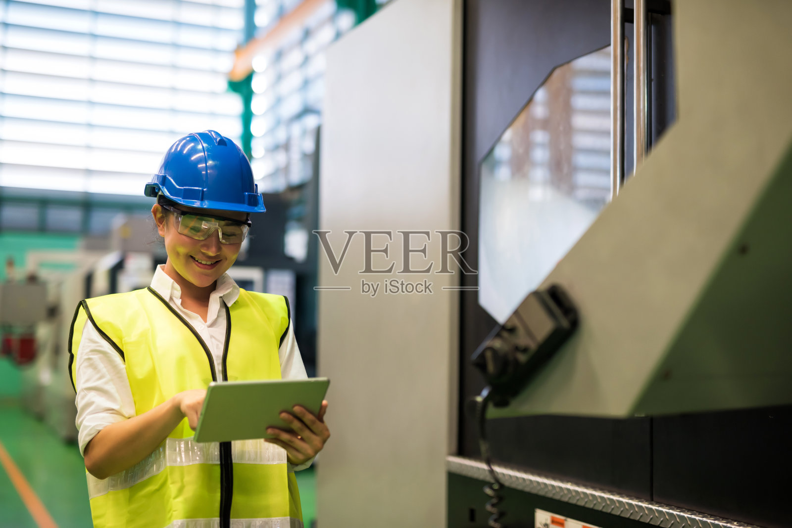 女人用平板电脑监控工厂机器照片摄影图片