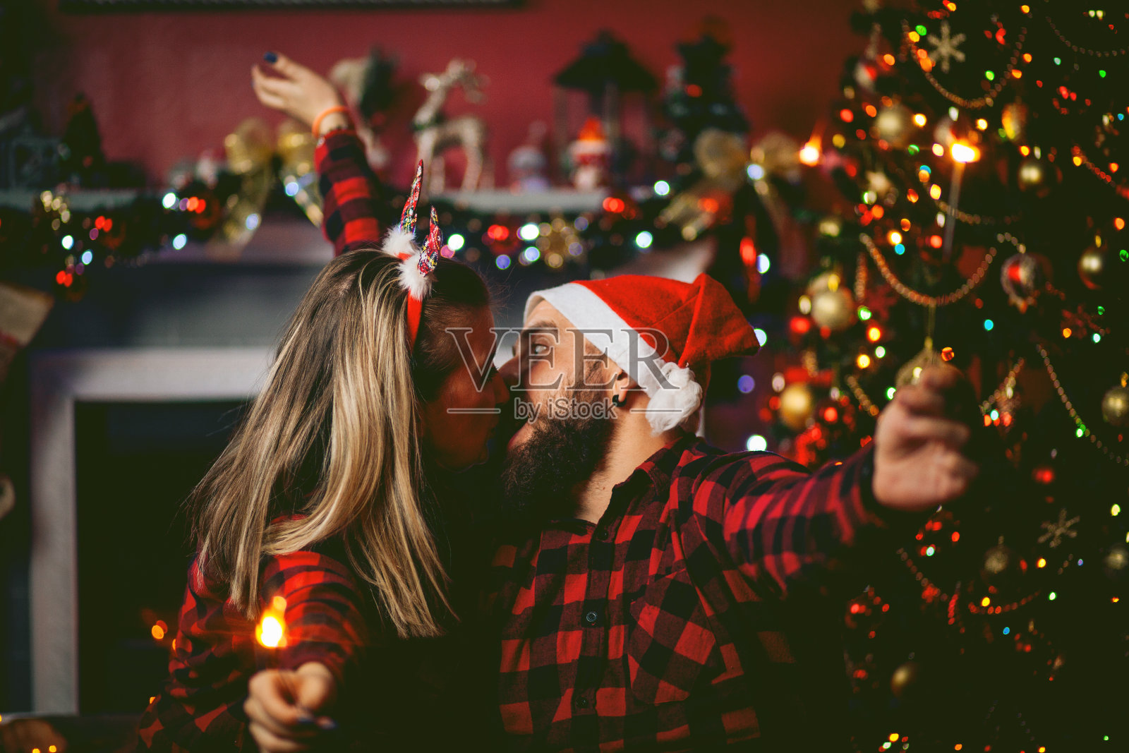 一对情侣在圣诞树旁接吻照片摄影图片