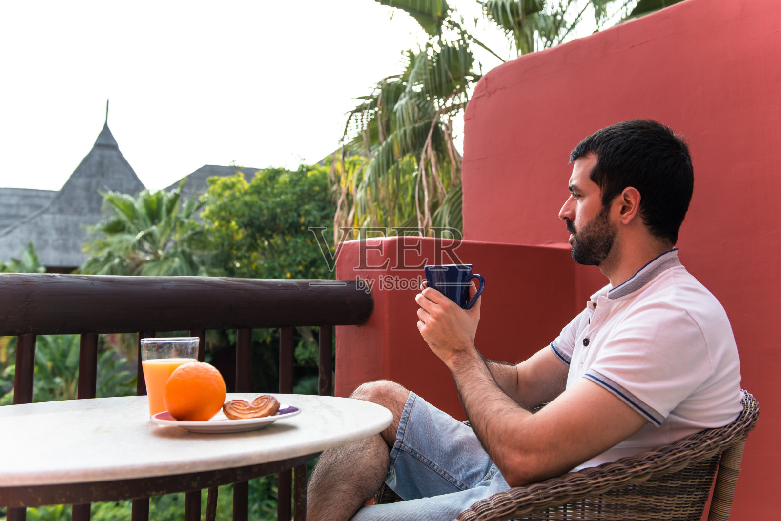 一个男人在酒店阳台上吃早餐照片摄影图片