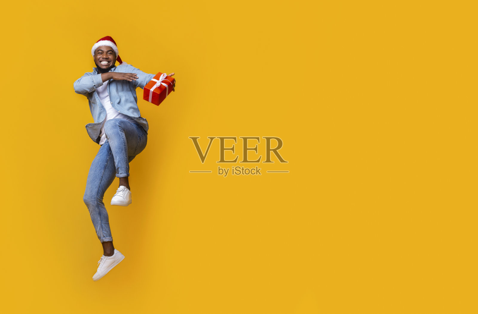 兴高采烈的黑人拿着礼盒，在空中跳了起来照片摄影图片