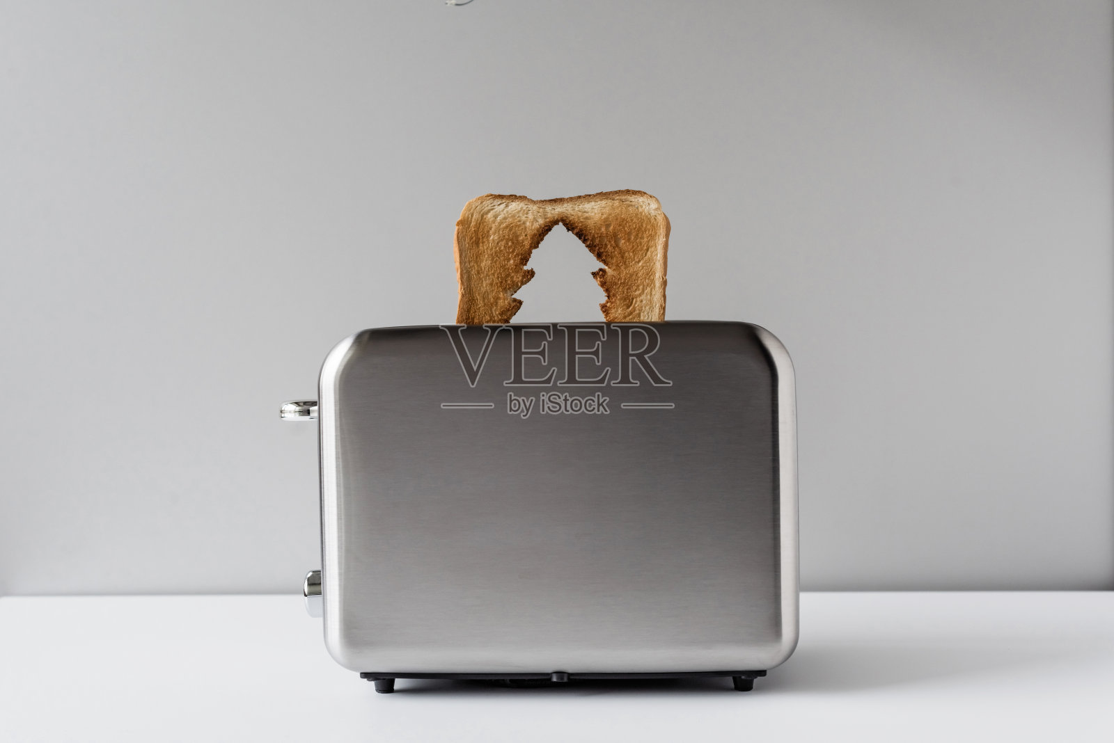 烤面包上的圣诞树洞，不锈钢复古烤面包机冒出来准备早餐。概念照片摄影图片