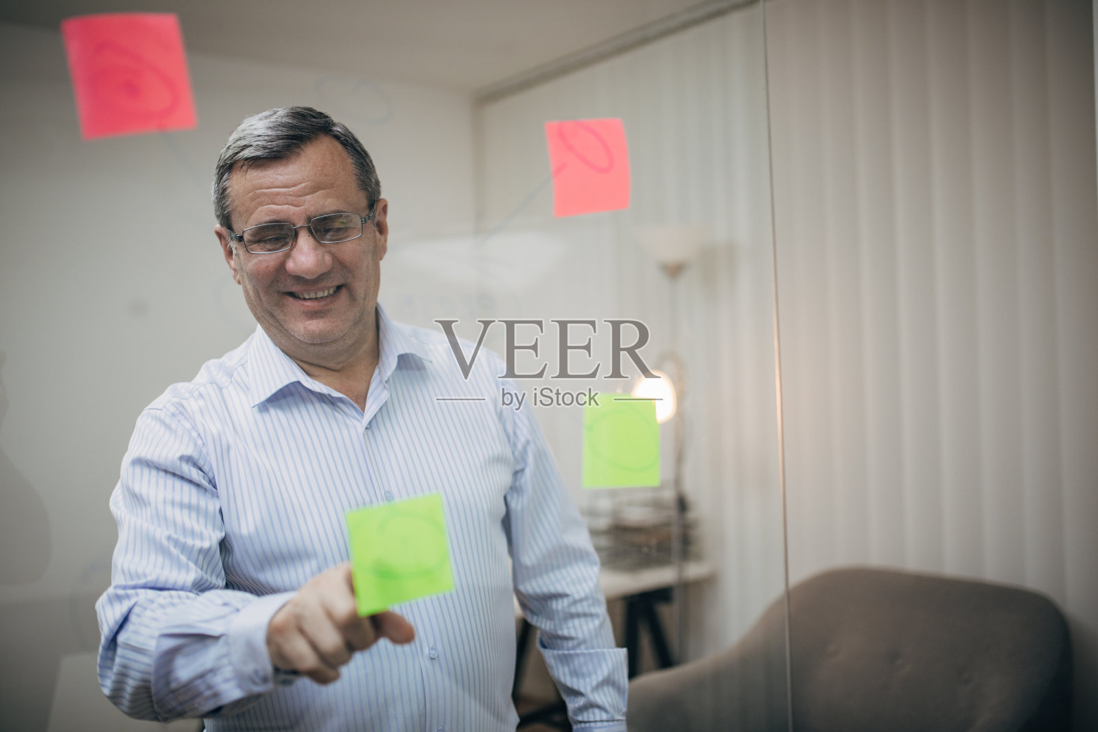 一位上了年纪的商人正在分析一个玻璃提醒器照片摄影图片