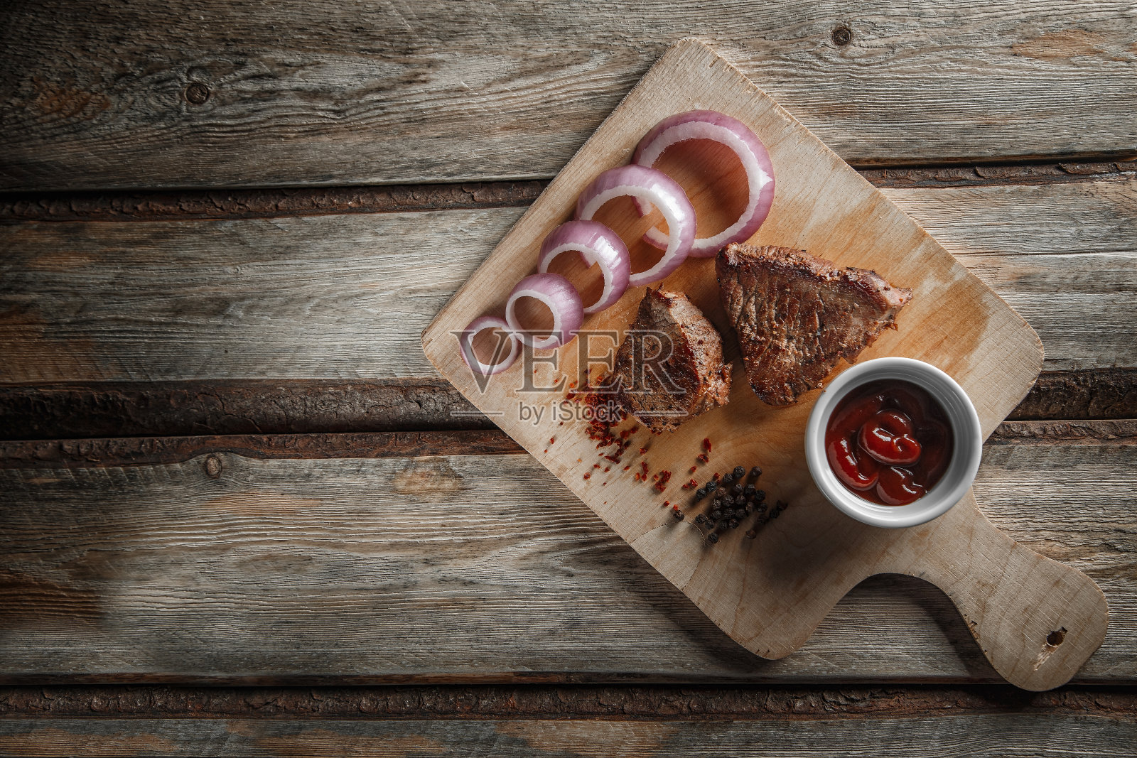在破旧的木头背景上放上调味料和番茄酱的烤肉照片摄影图片