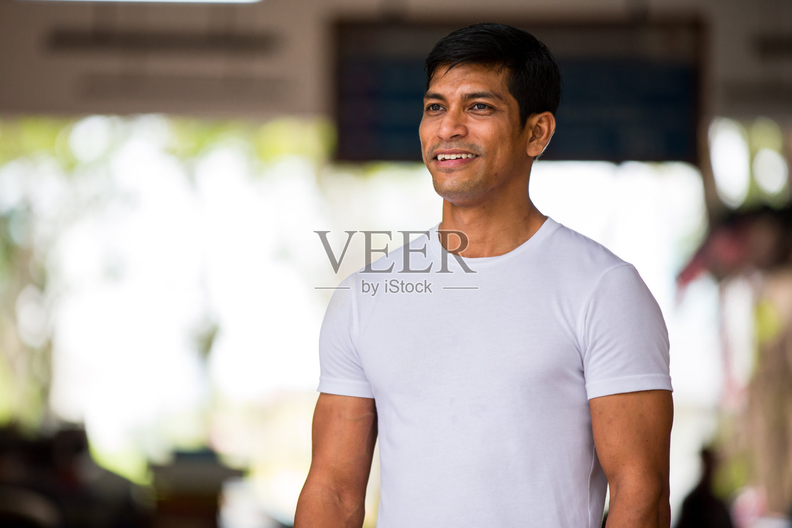 一个肌肉发达的马来人穿着白色t恤微笑着照片摄影图片