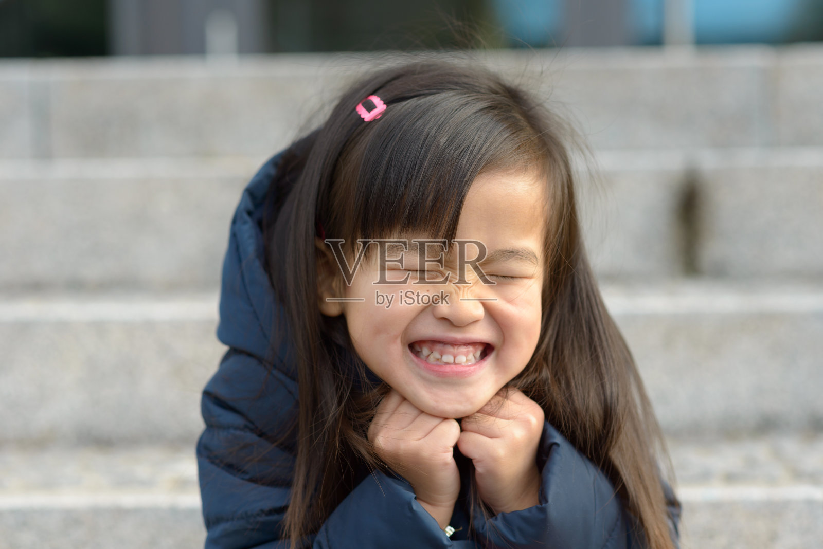 兴奋快乐的小女孩眯起眼睛照片摄影图片