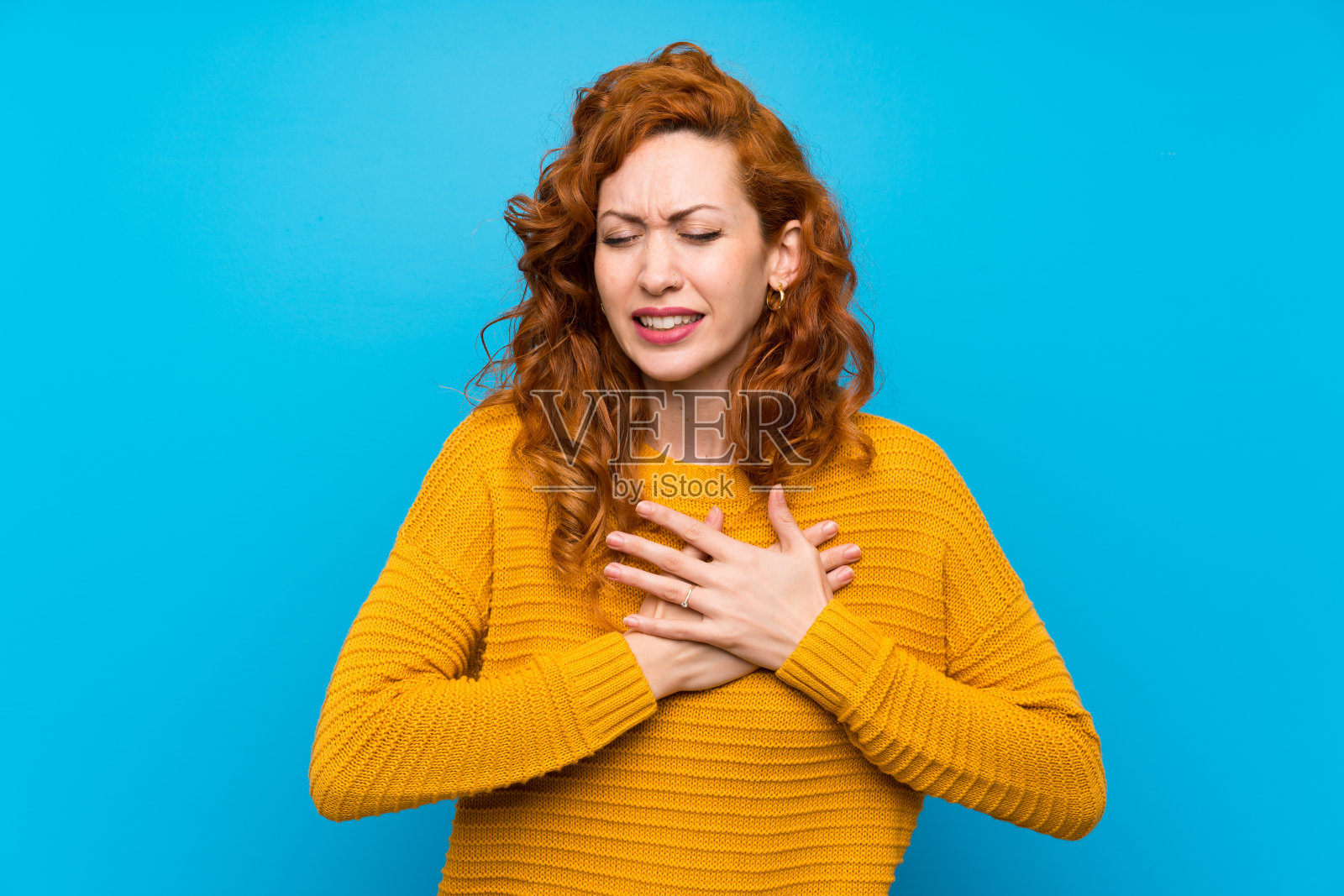 穿着黄色毛衣的红发女人，心里很痛照片摄影图片