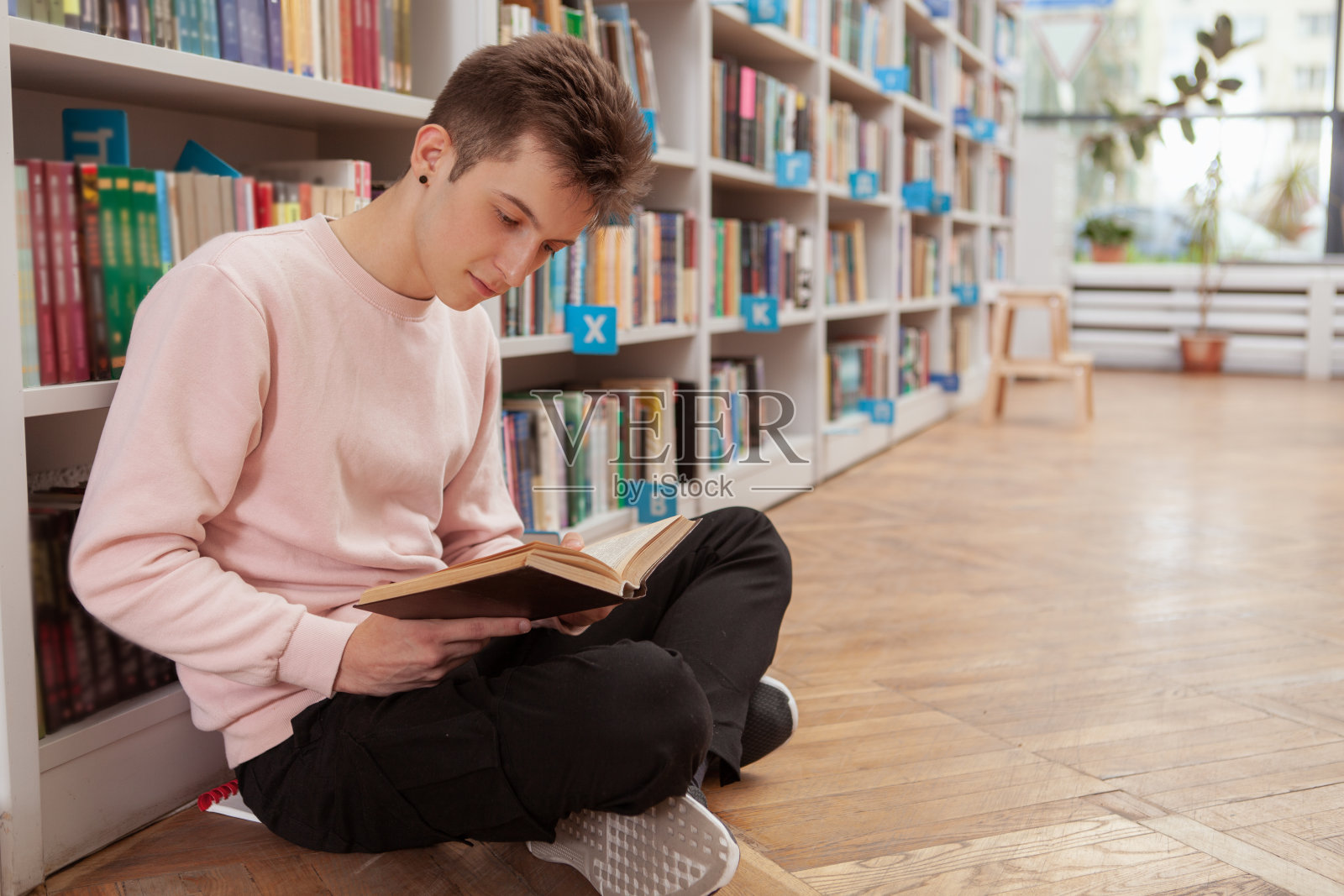 男学生在书店或图书馆照片摄影图片