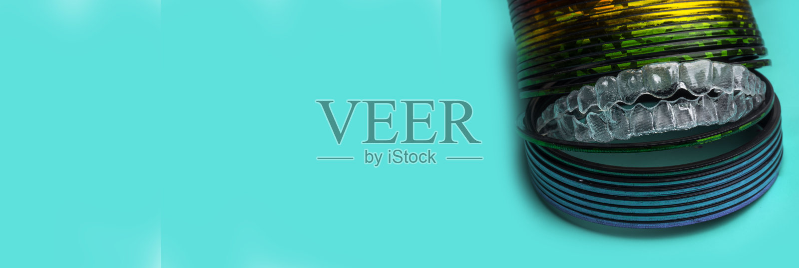 隐形牙齿支架或矫正器的旗帜来矫正牙齿。牙科矫正临时可移动矫直器在时髦的薄荷绿色背景照片摄影图片