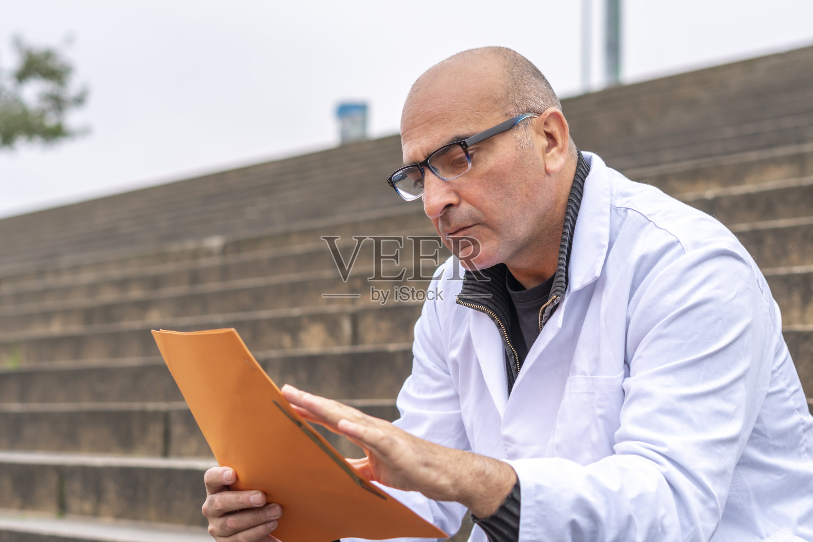 全科医生在户外阅读医疗报告照片摄影图片