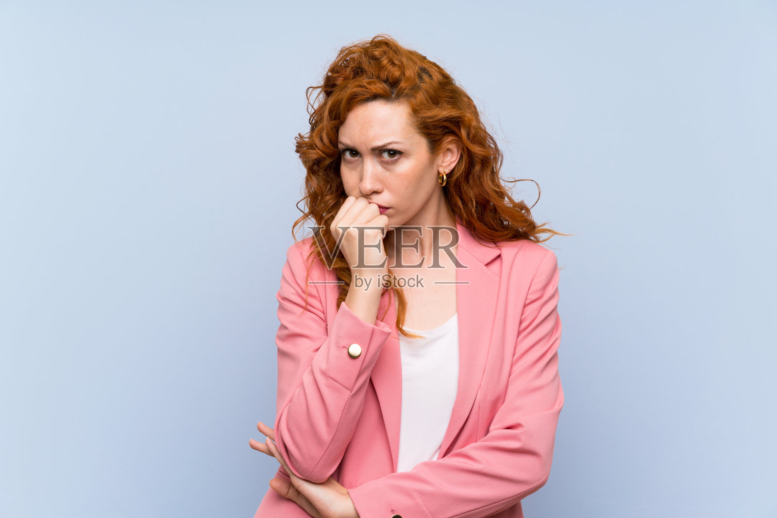 穿西装的红发女人在孤立的蓝色墙壁上有疑问照片摄影图片