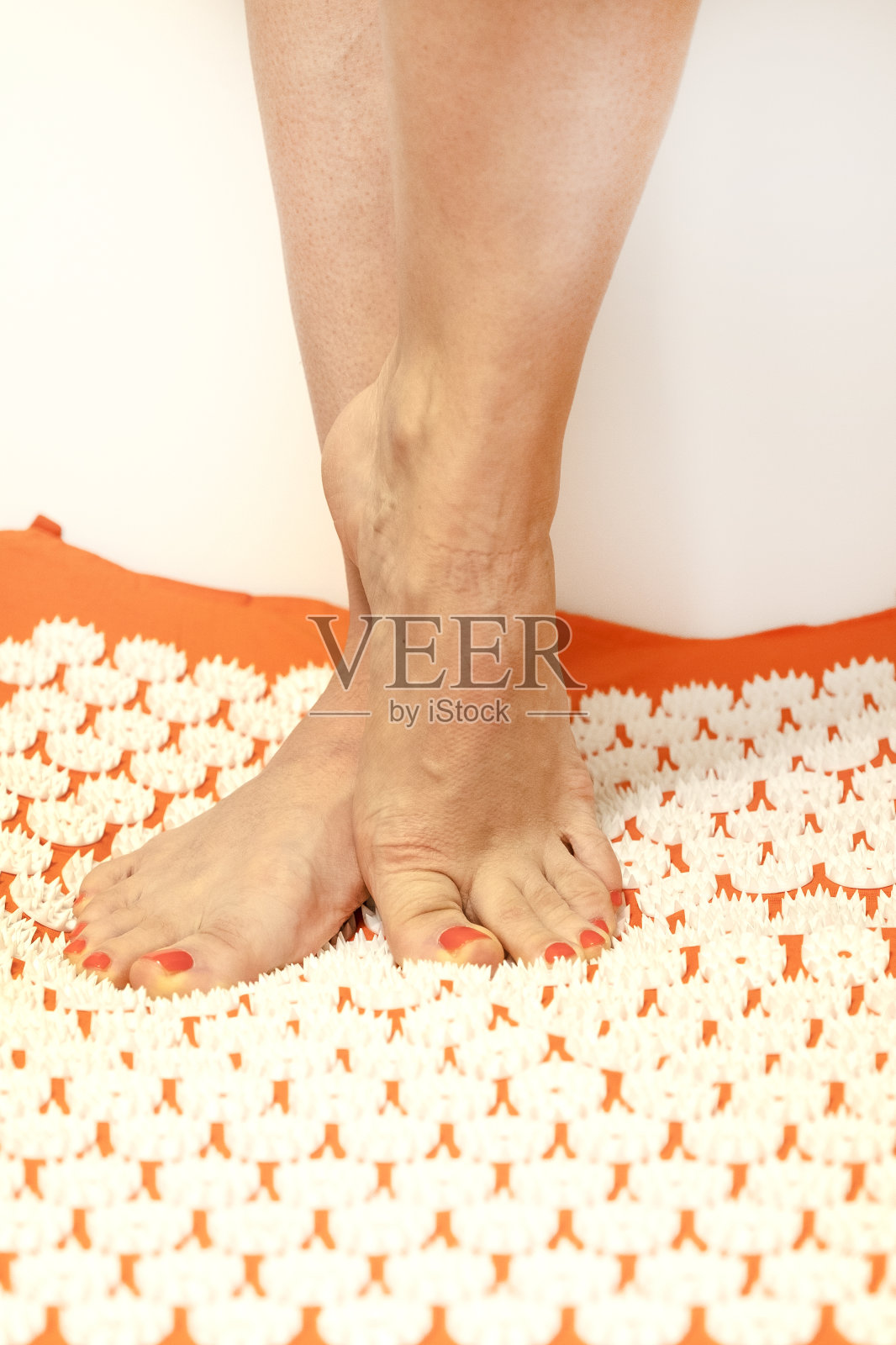 针灸。一个女孩的腿站在按摩地毯上。按摩的生活方式照片摄影图片