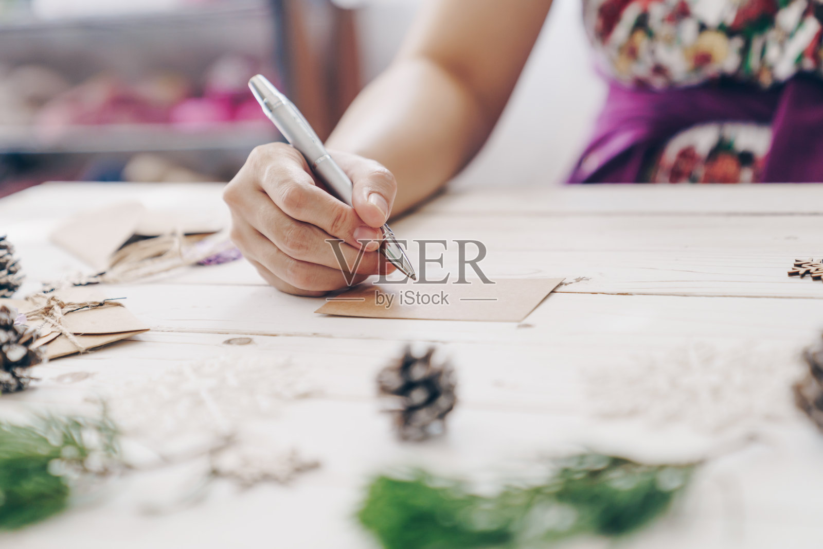 靠近的手女人写空的愿望清单和圣诞贺卡在木制的桌子上装饰圣诞节。照片摄影图片