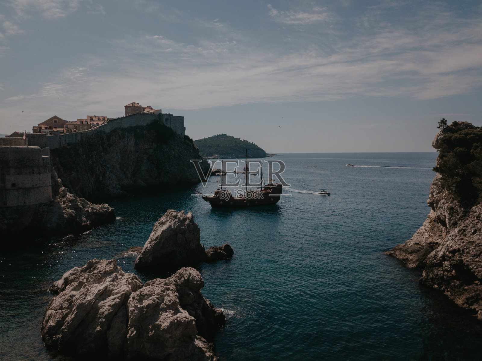 一艘有四根桅杆的大帆船在杜布罗夫尼克的岩石间抛锚照片摄影图片