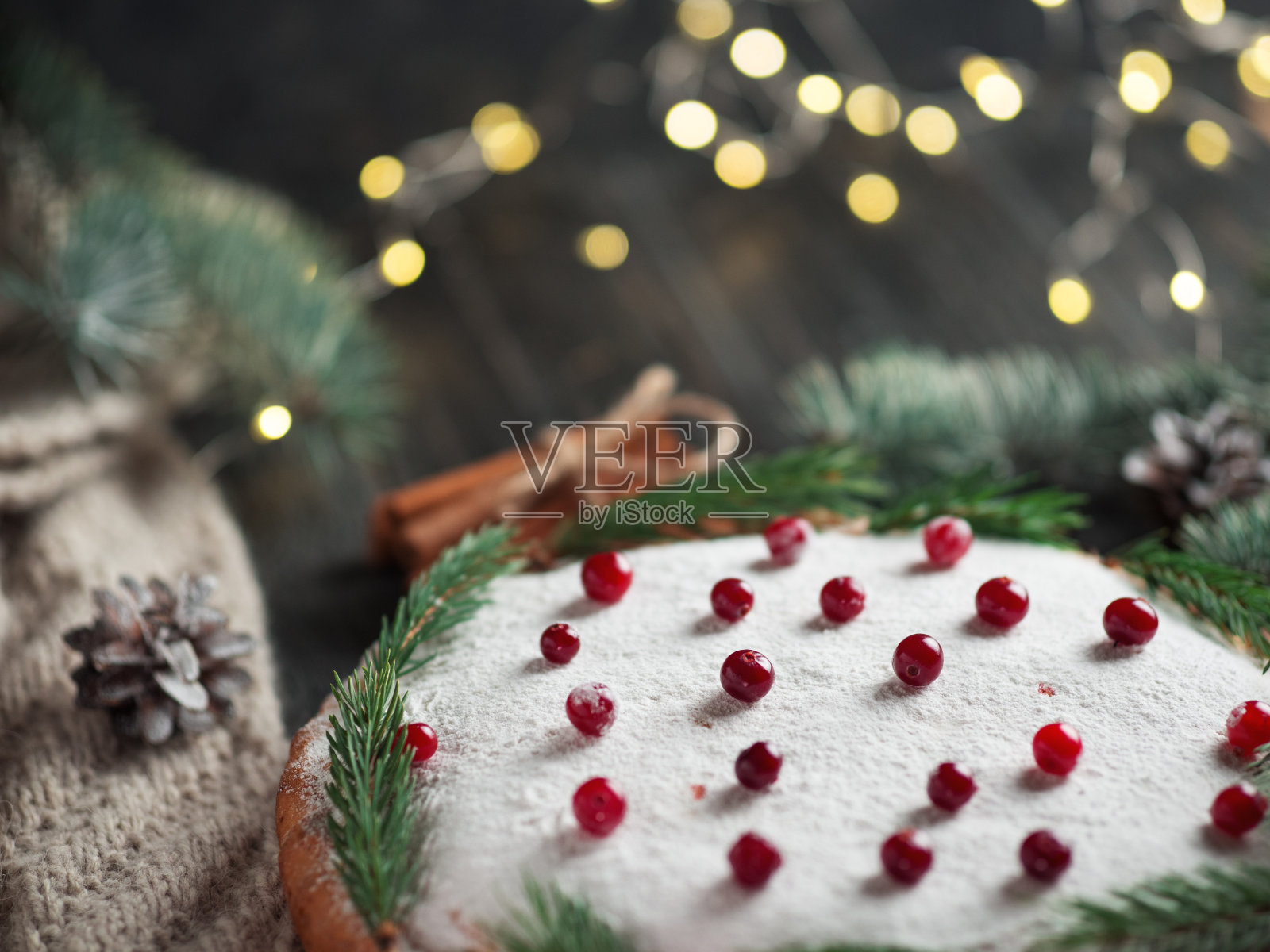 圣诞节自制蛋糕在木桌上撒上糖粉，用圣诞树树枝装饰照片摄影图片