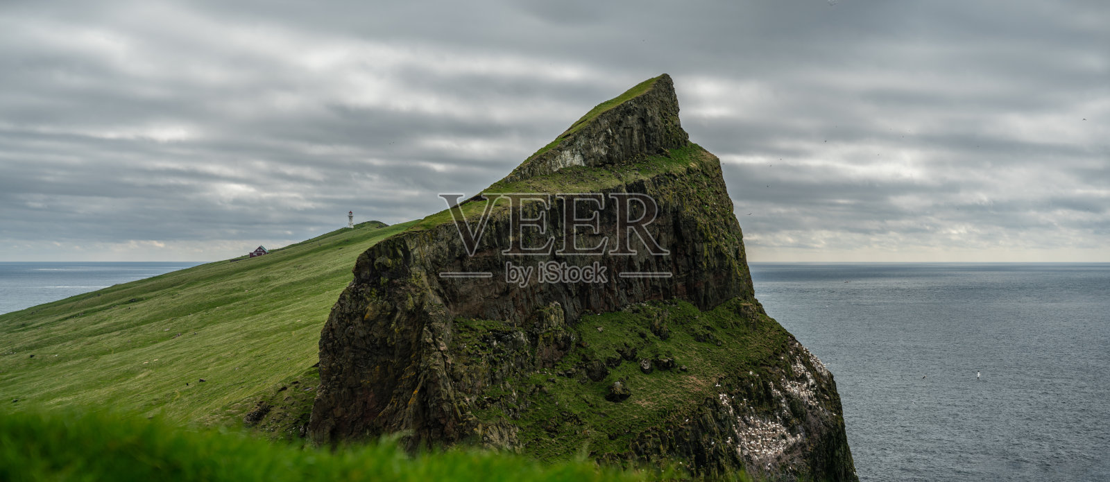 云彩下的迈肯斯岛上的灯塔照片摄影图片