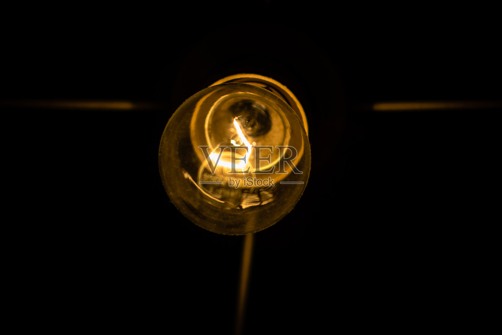 一个钨丝灯泡亮了起来。照片摄影图片