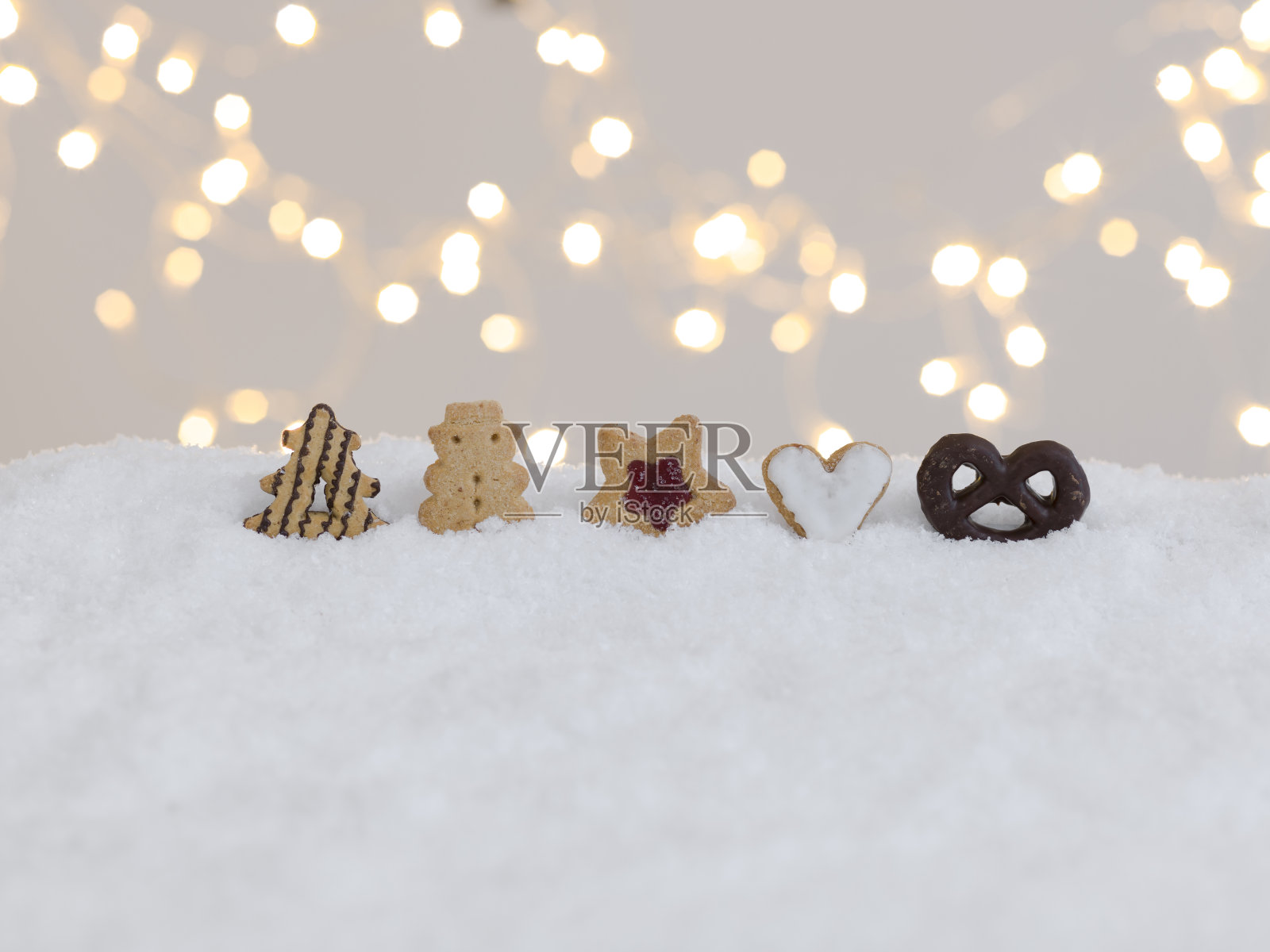 圣诞节背景与色彩缤纷的圣诞饼干在白色的雪照片摄影图片