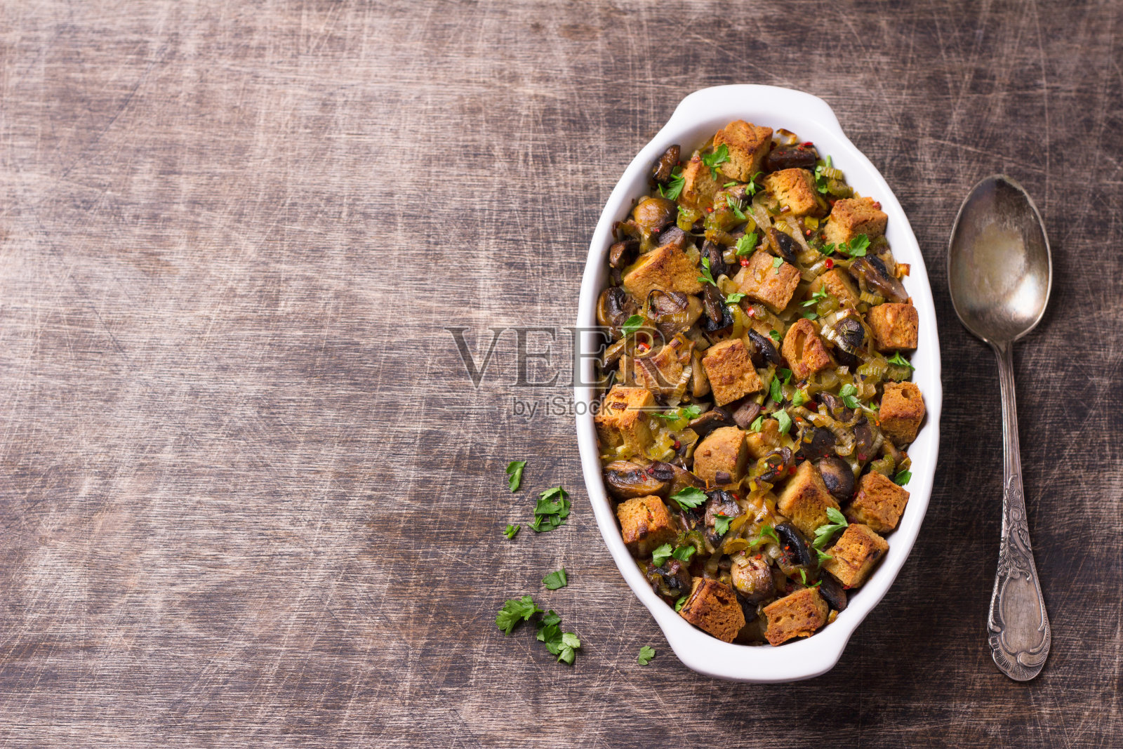 木桌上摆着蘑菇、韭菜和酥脆的面包丁，俯视图照片摄影图片