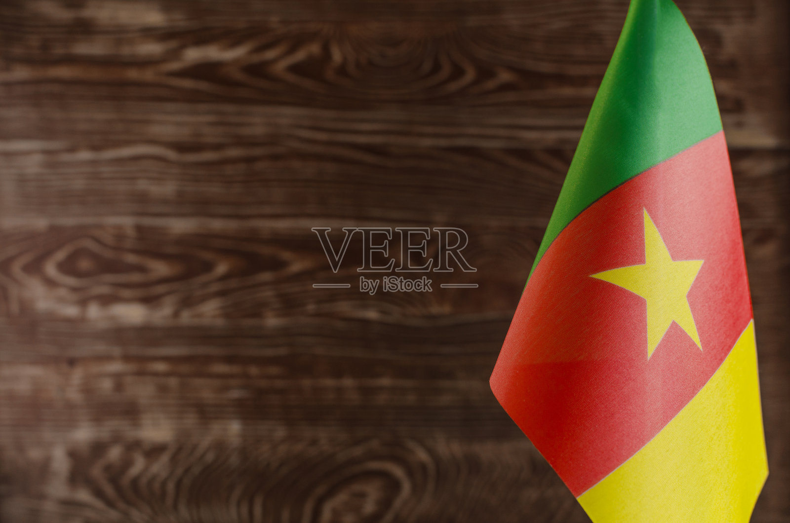 喀麦隆共和国国旗的碎片在前景空间的文本模糊背景照片摄影图片