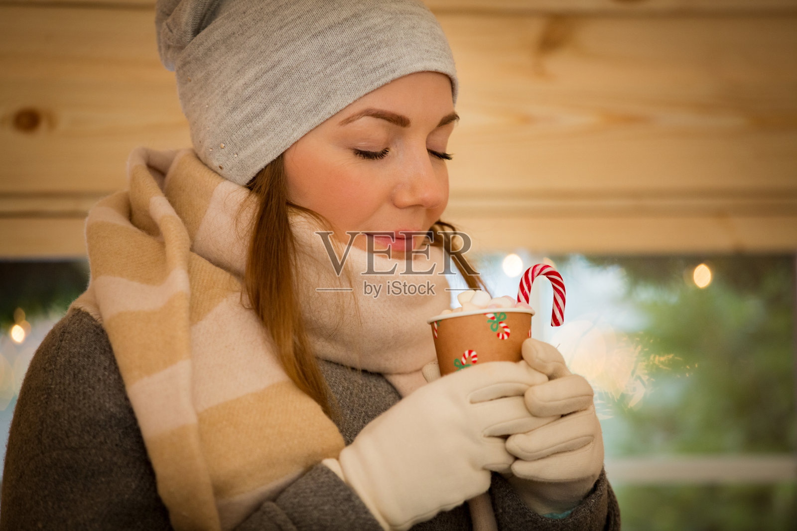 年轻女子喝着一杯热巧克力和棉花糖照片摄影图片
