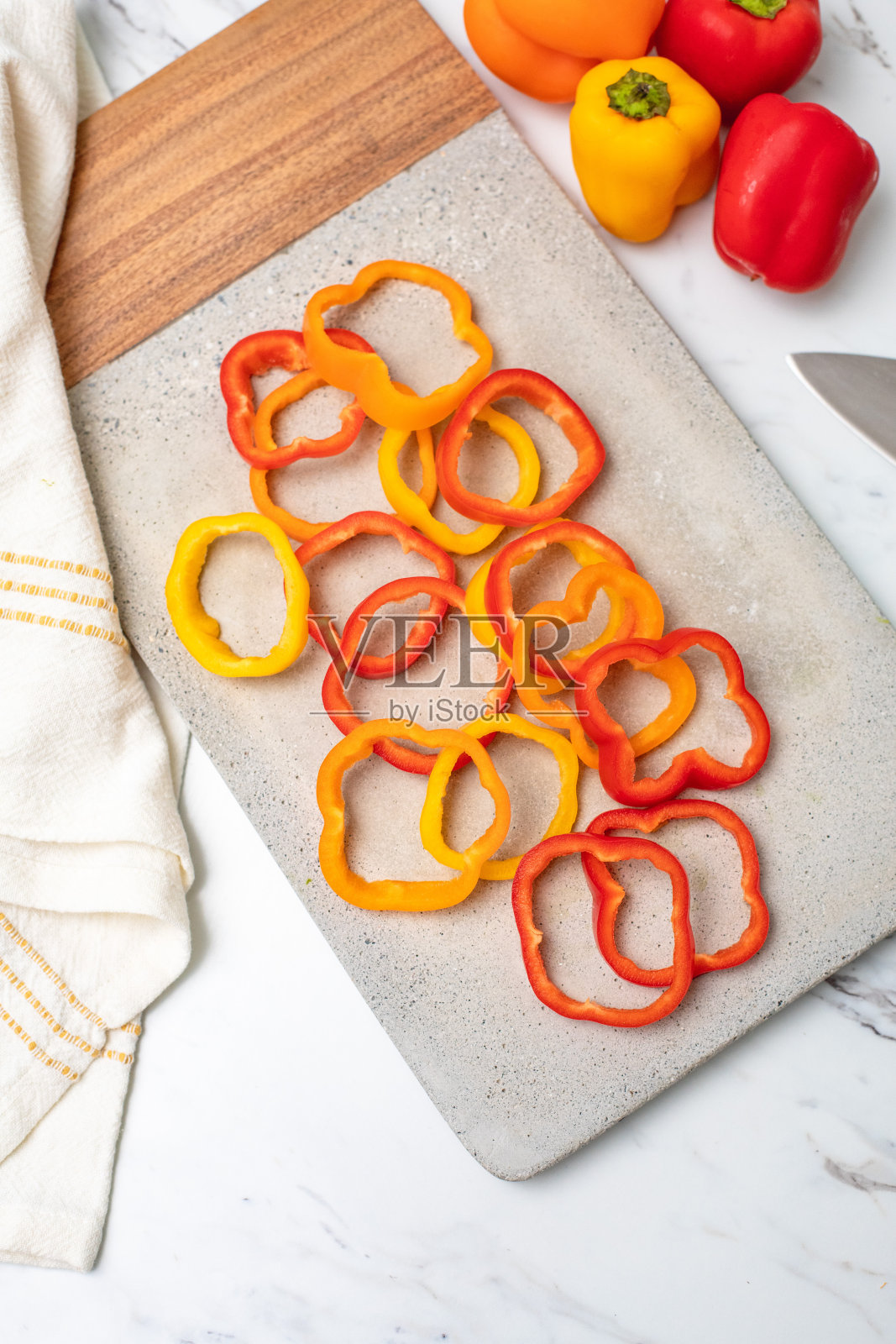 红、黄、橙三种甜椒切在水泥切板上照片摄影图片