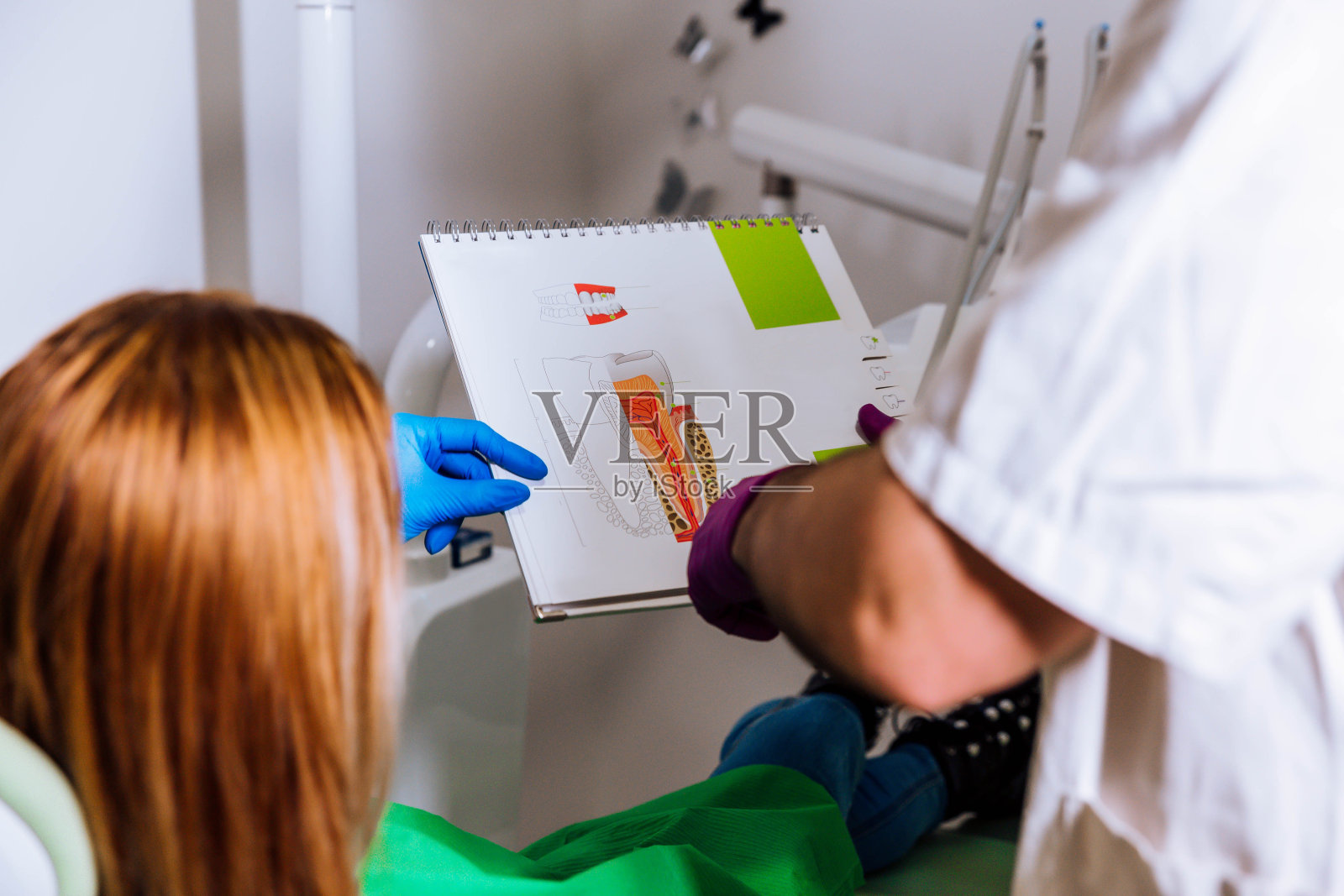 两名牙医向病人展示和解释牙齿疾病的治疗方法照片摄影图片