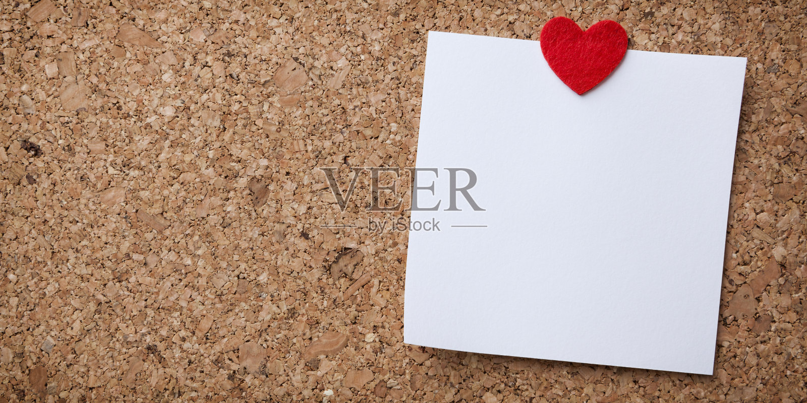 空白黄色纸便条垫提醒贴在软木公告板上。文本的空白。办公设备。照片摄影图片