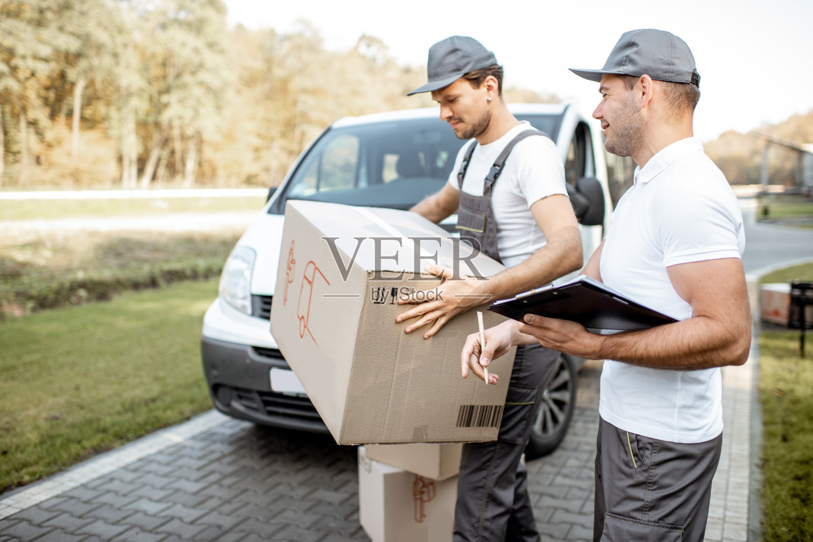 用汽车递送包裹的快递员照片摄影图片