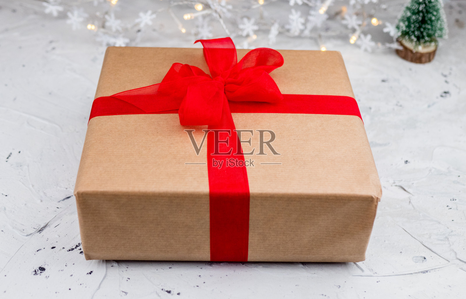 用红色丝带蝴蝶结、圣诞星星和白色雪花包裹的复古礼盒照片摄影图片