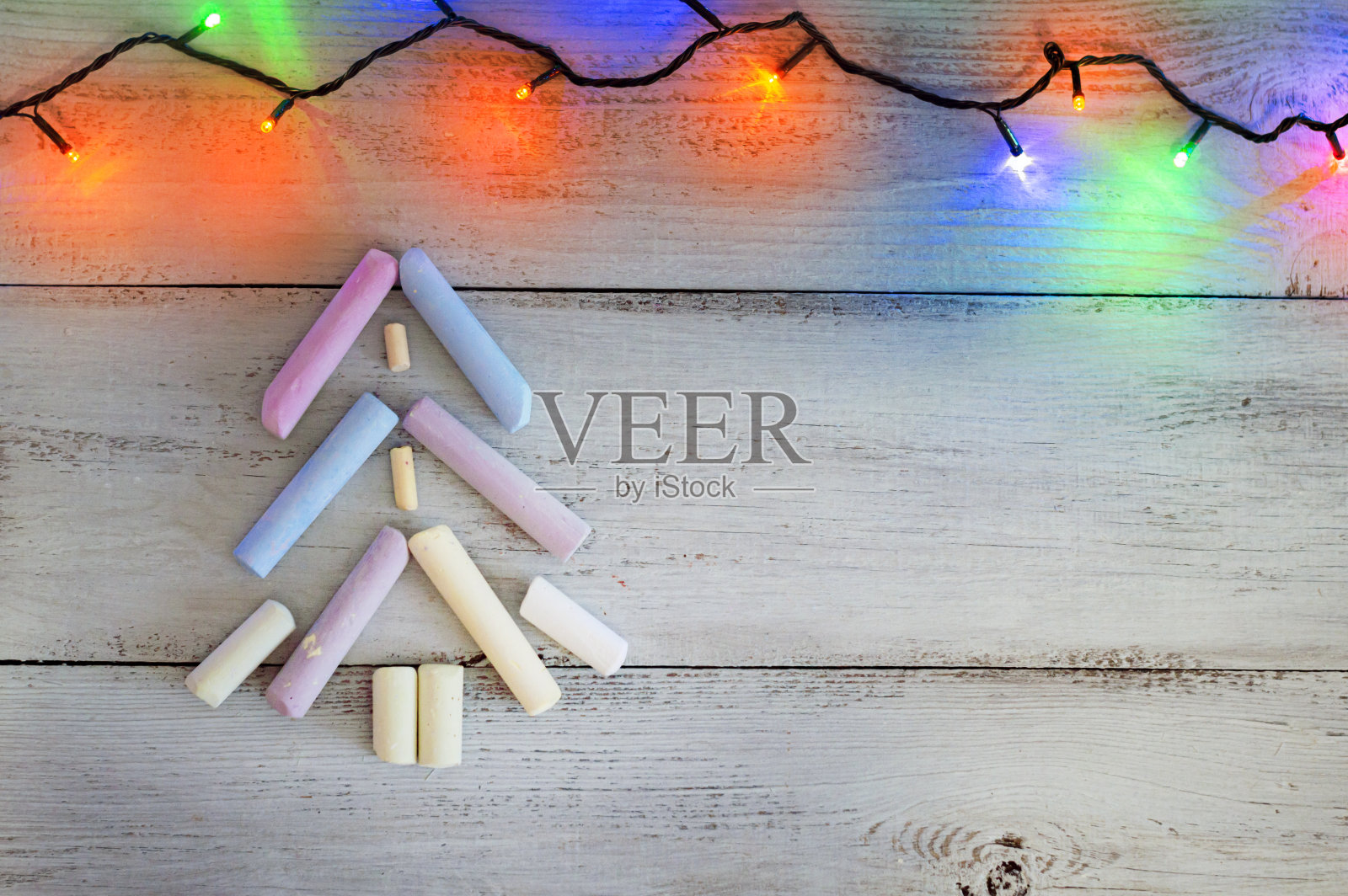 创意圣诞树由蜡笔在木制背景和明亮的花环。照片摄影图片