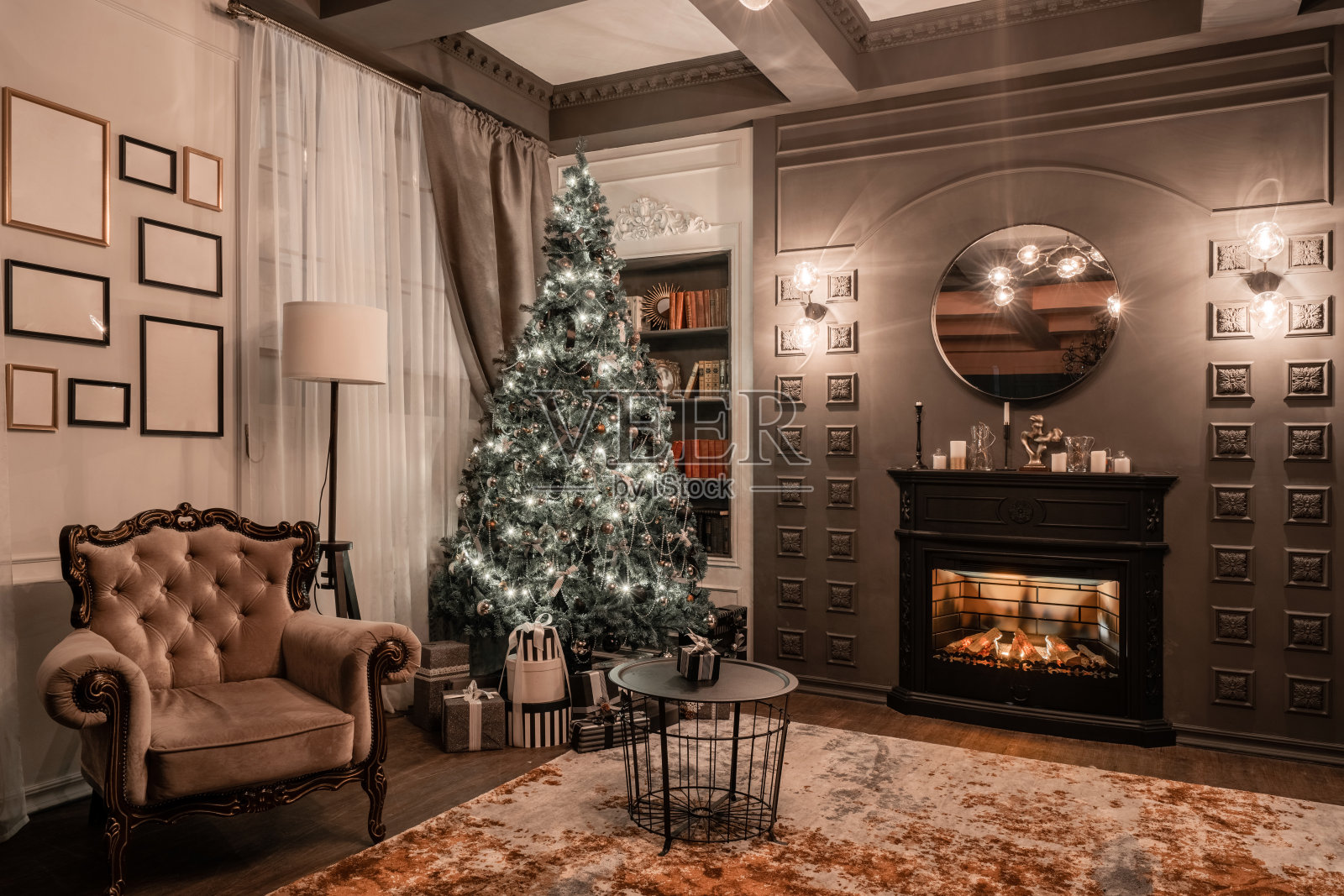 烛光下的圣诞夜晚。经典的公寓有壁炉，装饰的树，沙发，大窗户和枝形吊灯。照片摄影图片