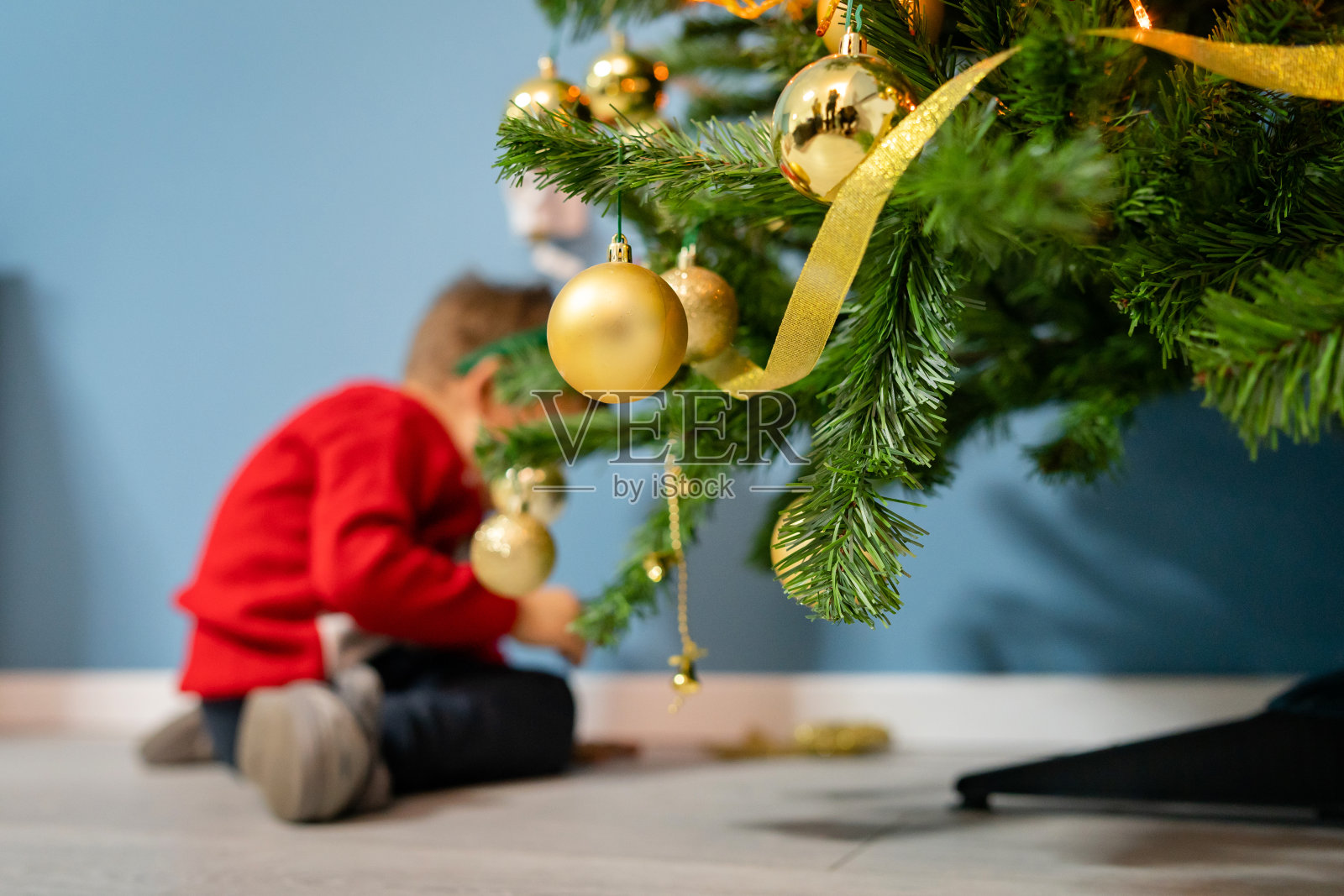 小男孩两三岁在家装饰圣诞树新年假期概念低角度选择重点照片摄影图片