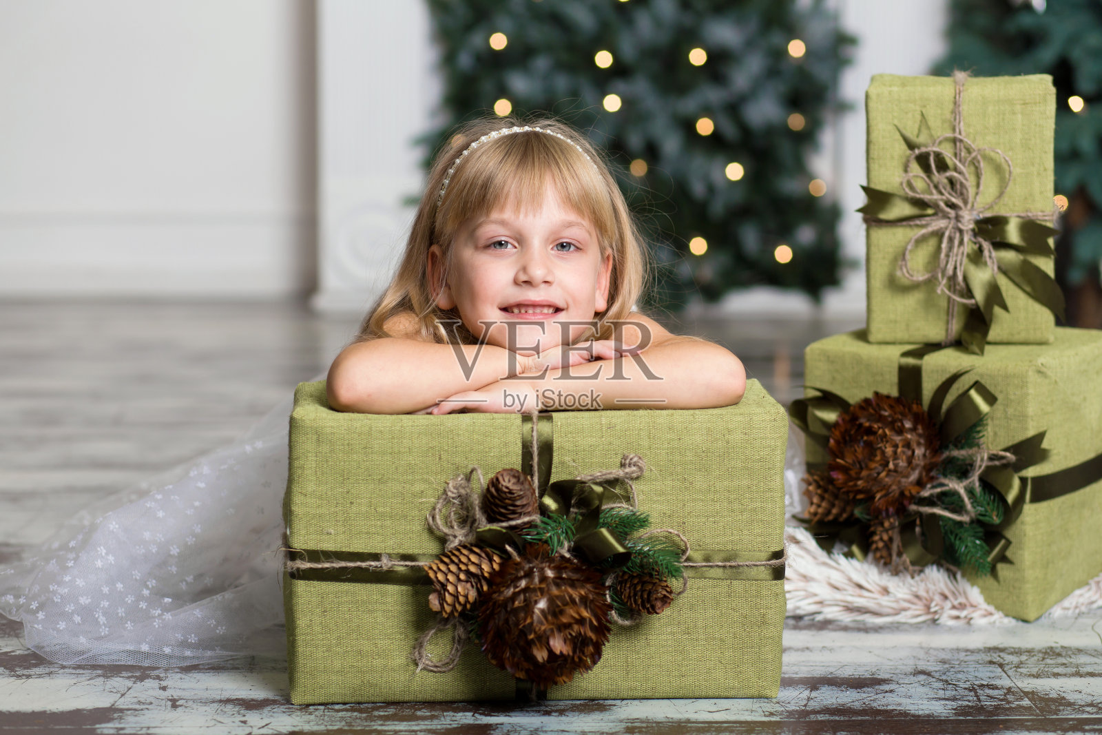 快乐的女孩拿着一个大盒子，上面有一份礼物。寒假、圣诞节和人的概念。照片摄影图片