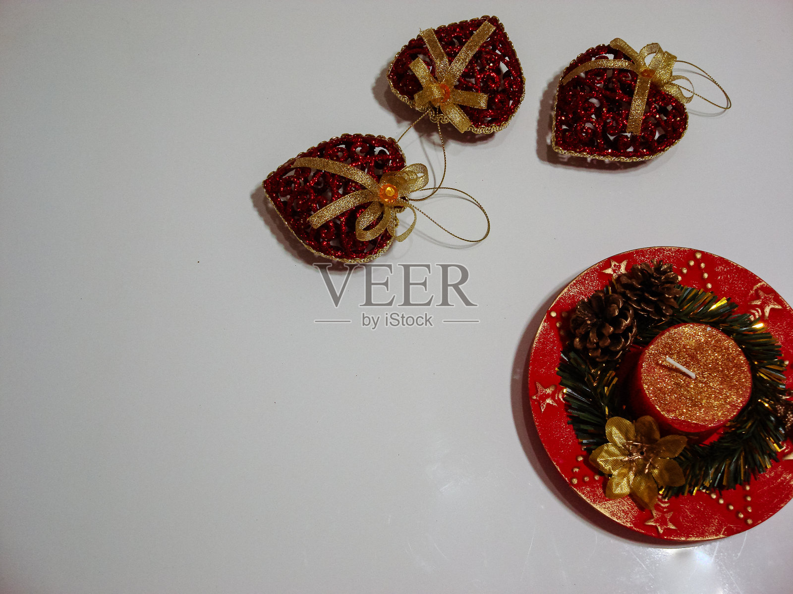 圣诞装饰在白板上。圣诞概念，装饰圣诞蜡烛和闪闪发光的心形圣诞球。照片摄影图片