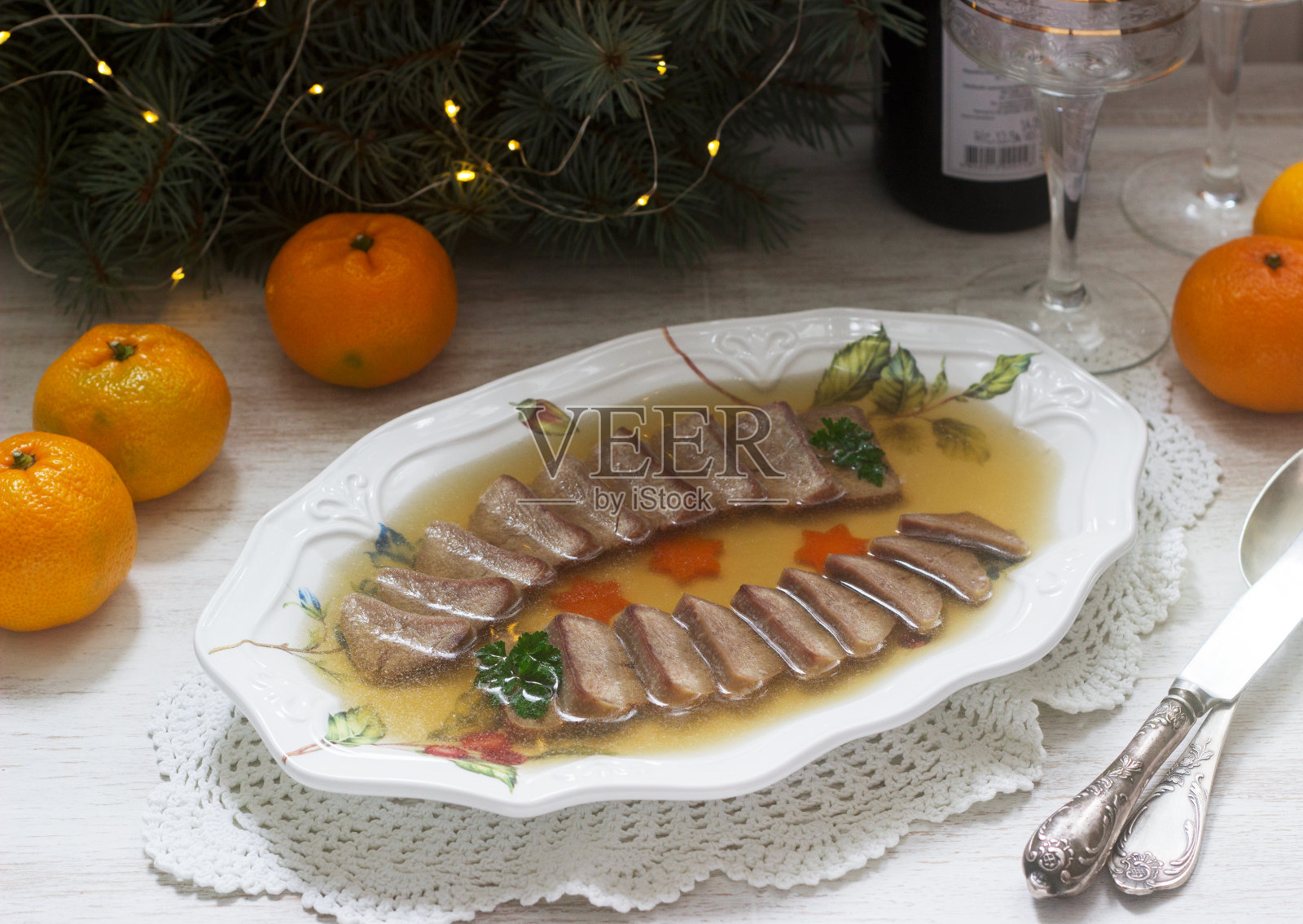 用煮过的胡萝卜和欧芹装饰舌头的肉冻，在节日的背景下。乡村风格。照片摄影图片