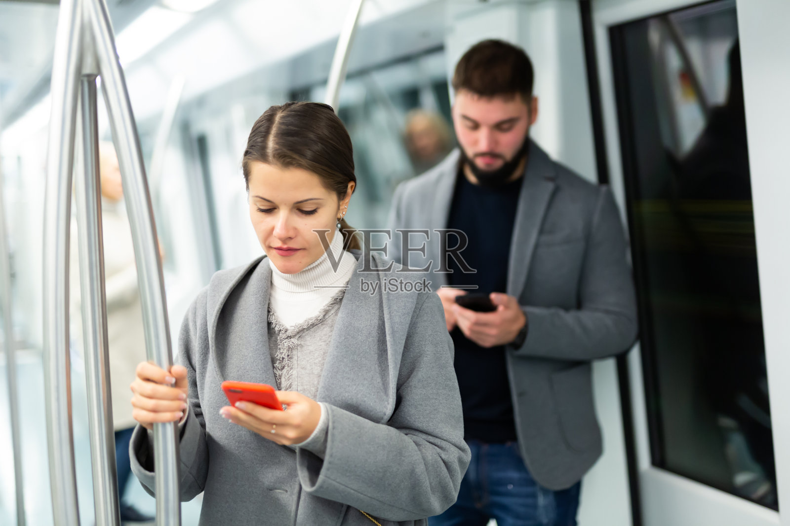 年轻女子在地铁里拿着手机照片摄影图片