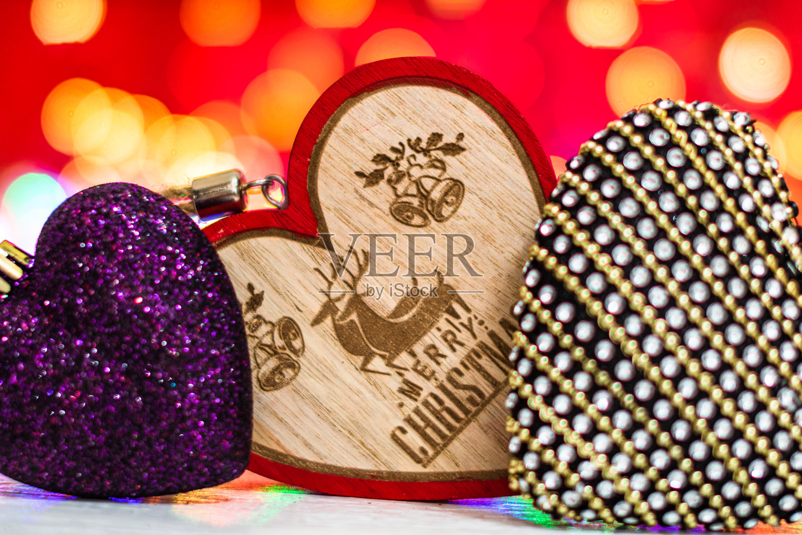 五彩缤纷的心形圣诞饰品。圣诞合成上模糊的灯光背景。照片摄影图片