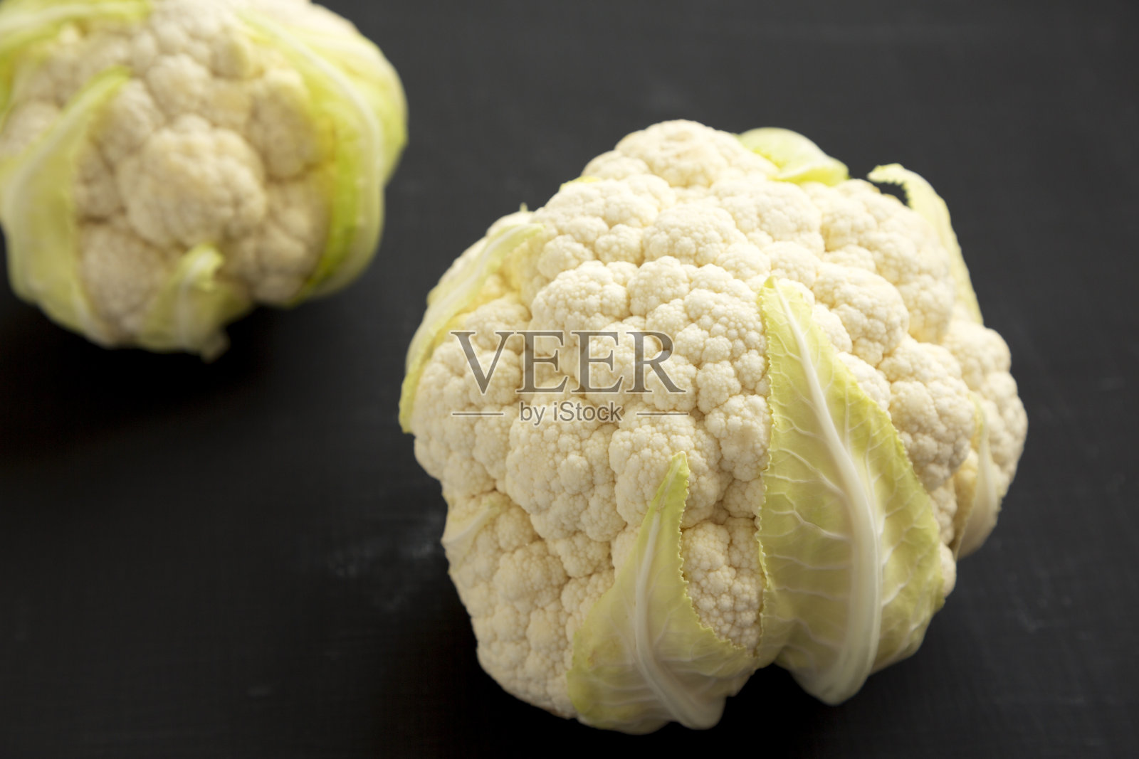 生菜花头在一个黑色的背景，低角度的观点。特写镜头。照片摄影图片